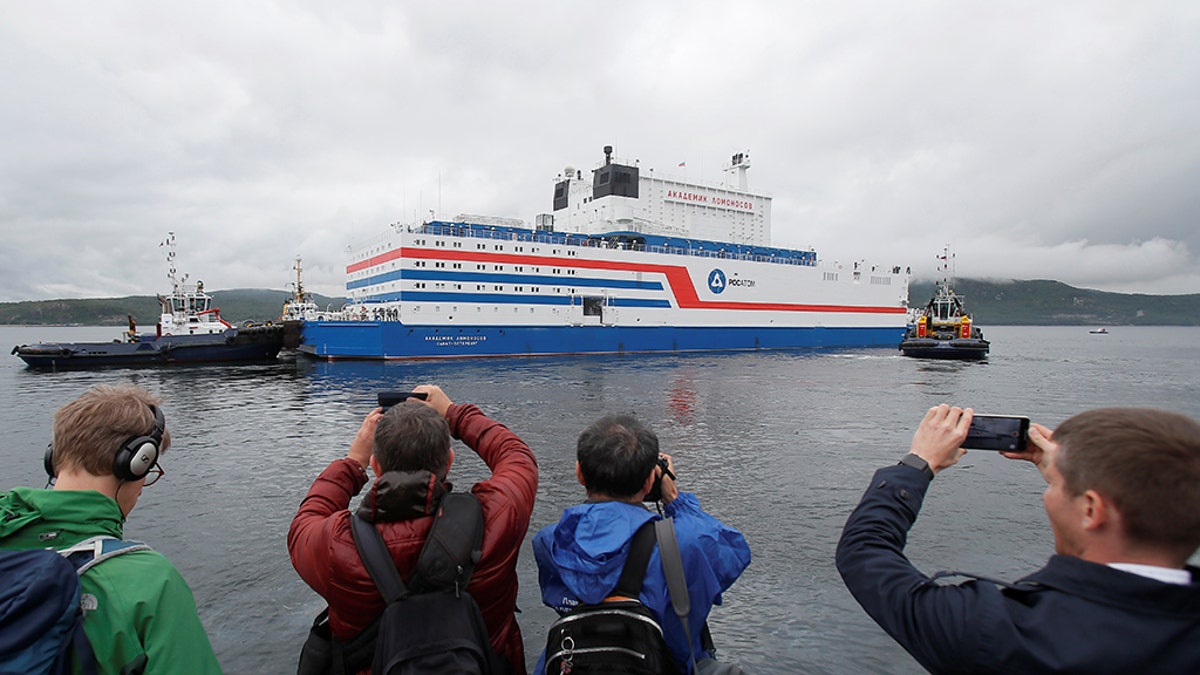 People take pictures of Russia's floating nuclear power plant Akademik Lomonosov as it leaves port Friday in Murmansk.