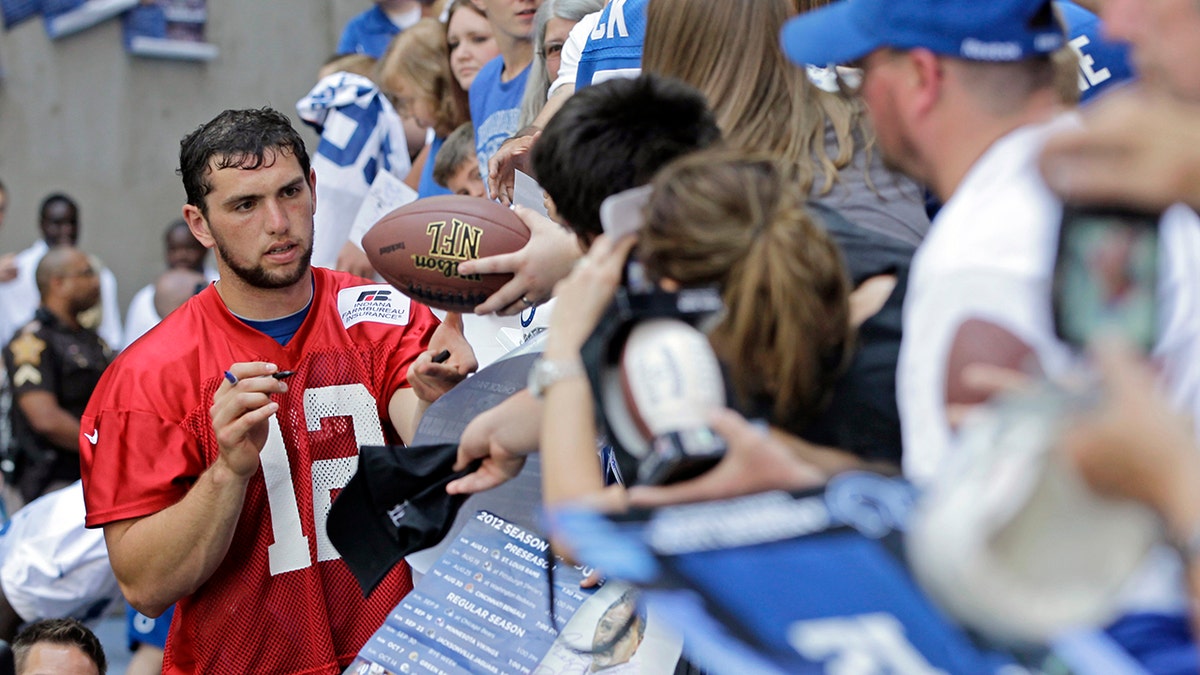 Indianapolis Colts quarterback Andrew Luck (12) signs autographs for fans following the NFL football team's practice in Indianapolis. (AP Photo/Darron Cummings, File)