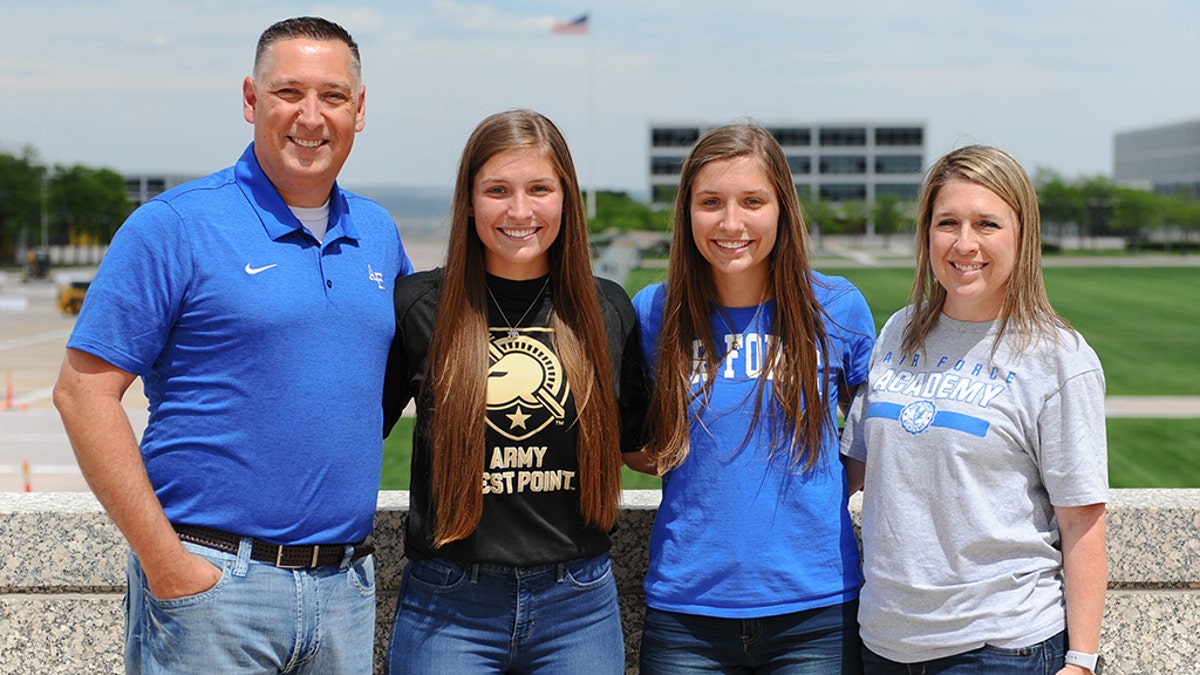 Aubrie and Emma Kuhrt (center), twin sisters from Texas who split to attend separate U.S. military academies, with their parents, Michael (left) and Shannon (right). (U.S. Air Force Academy Public Affairs)