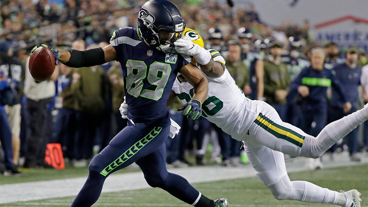 Seattle Seahawks wide receiver Doug Baldwin (89) being tackled by Green Bay Packers defensive back Bashaud Breeland, right, during an NFL game in November 2018. (AP Photo/Elaine Thompson, File)