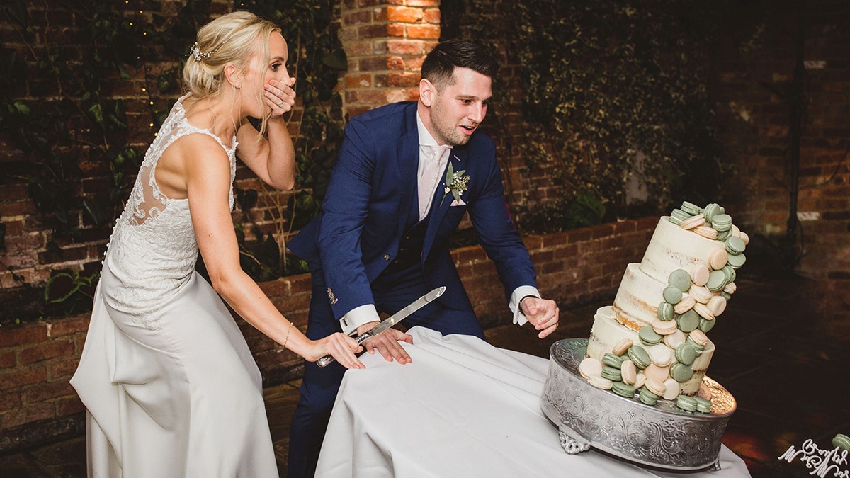 The couple had just started cutting the cake when the table tipped — and the cake went down with it.
