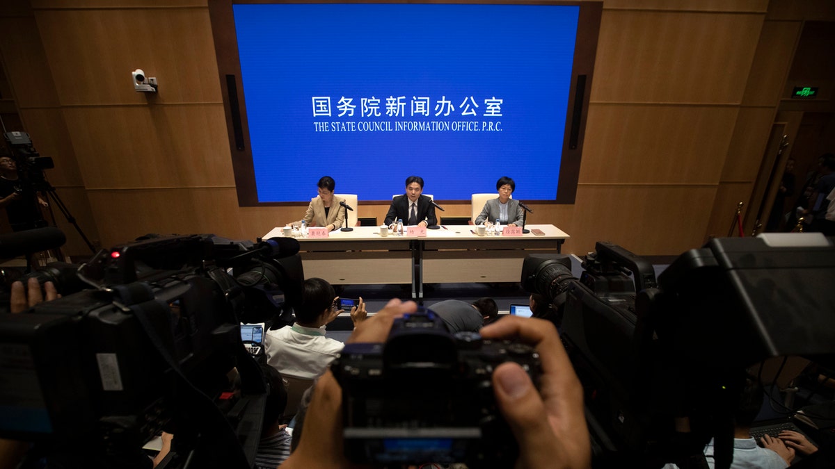 Yang Guang, center, spokesman for the Chinese Cabinet's Hong Kong and Macao Affairs Office, speaks during a press conference in Beijing, Tuesday, Aug. 6, 2019.