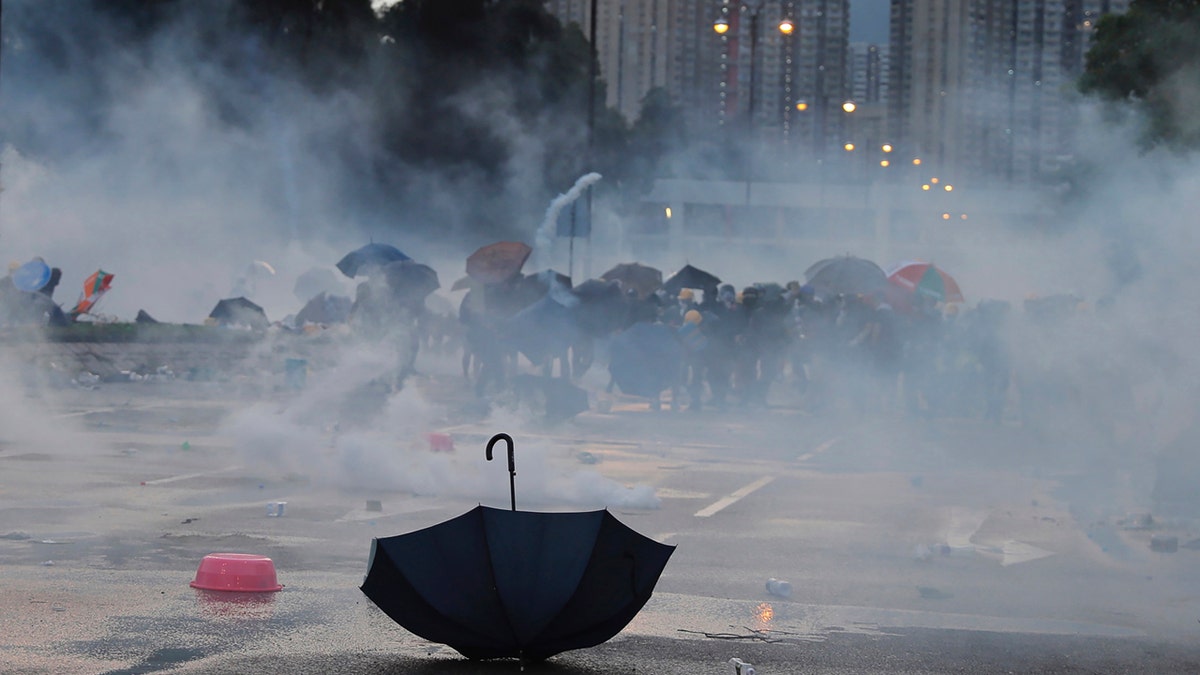 An umbrella is abandoned as protesters pull back from tear gas on Monday, Aug. 5, 2019.