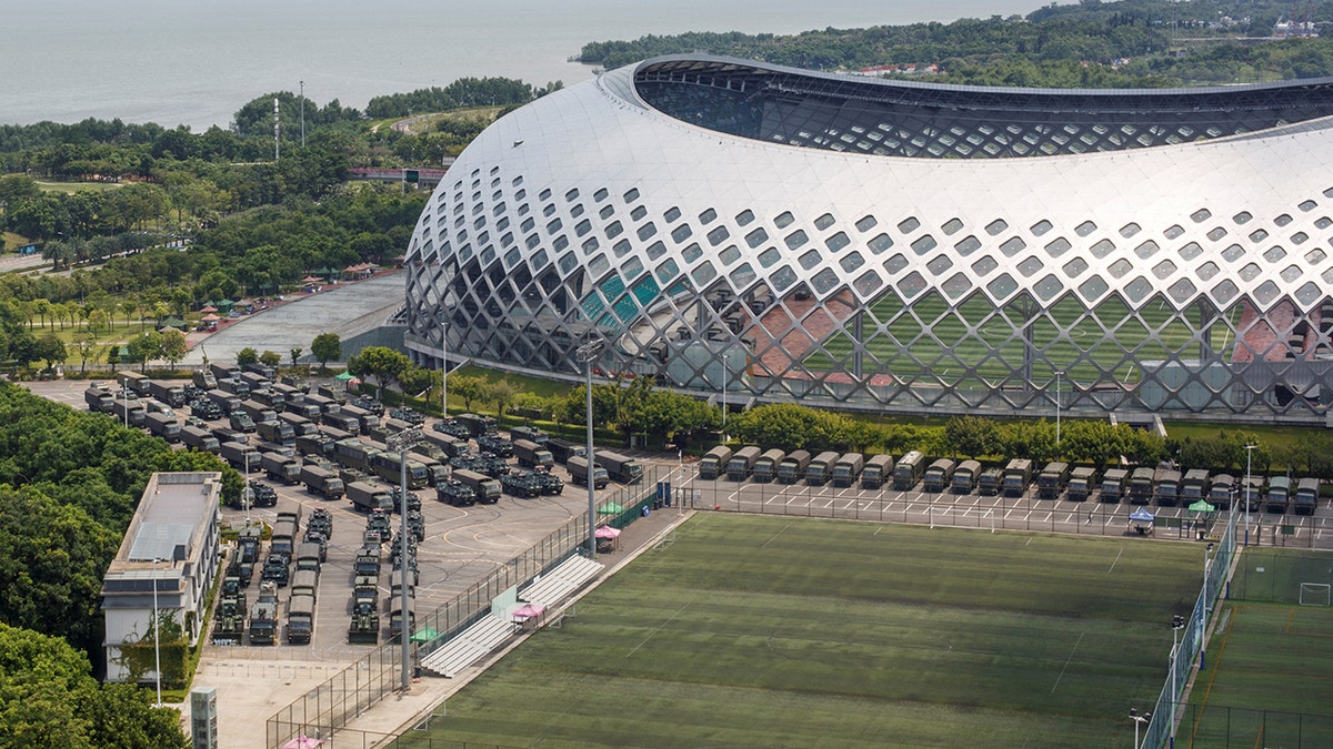 Military vehicles are parked on the grounds of the Shenzhen Bay Sports Center in Shenzhen, China August 15.