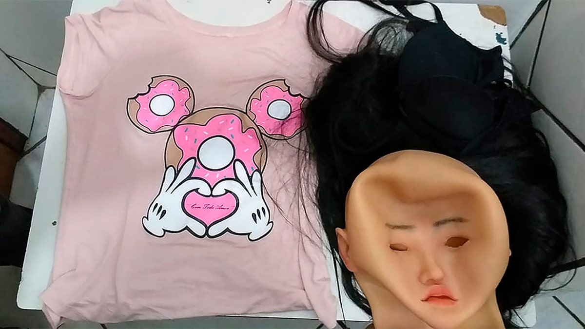 This photo released by the Rio de Janeiro Penitentiary Administration Secretariat, shows the mask, wig and women's clothing that was used by a man authorities identify as jailed Brazilian drug trafficker Clauvino da Silva, alias “Baixinho,” which means "Shorty," in an attempt to escape from jail in Rio de Janeiro, Brazil, Sunday, Aug. 4, 2019. (Rio de Janeiro Penitentiary Administration Secretariat via AP)