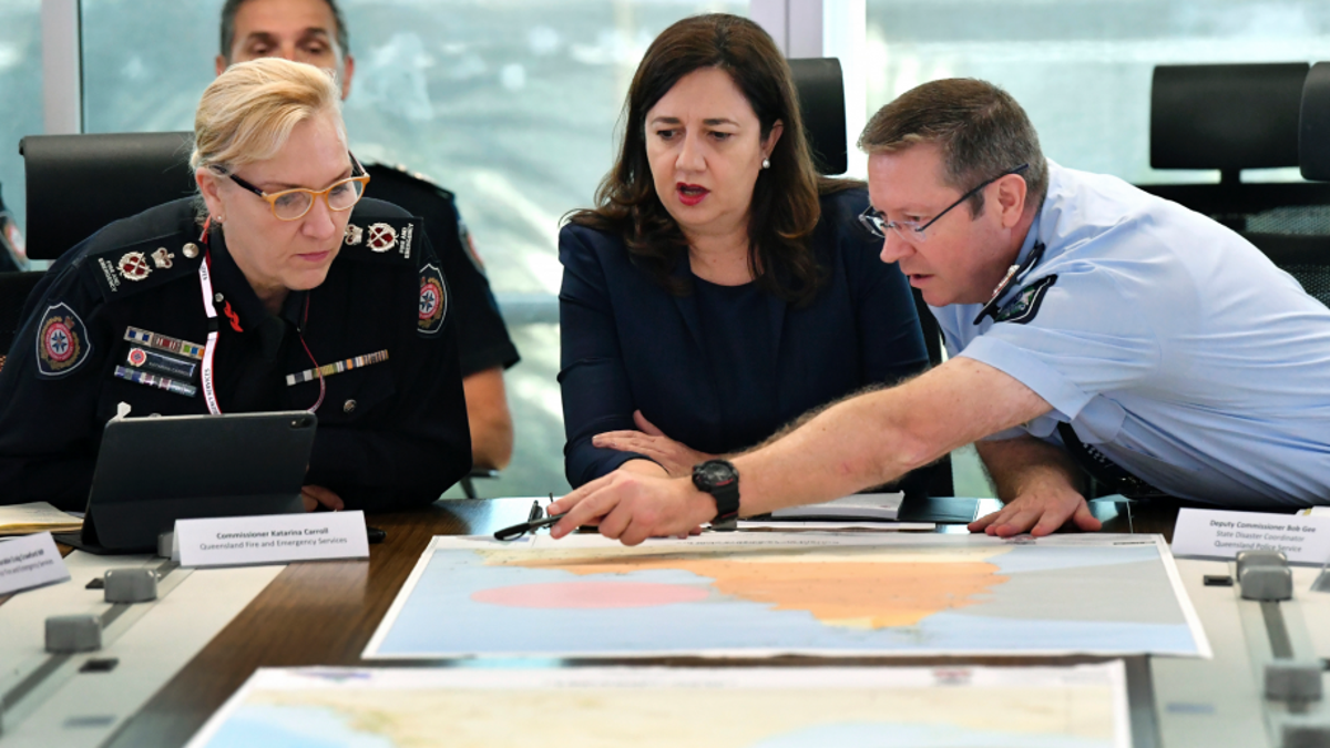 In this March 19, 2019, photo, Queensland Fire and Emergency Services Commissioner, Katarina Carroll (left), Queensland Premier Annastacia Palaszczuk (center) and Queensland Police Deputy Commissioner Bob Gee (right) are seen during a meeting of the Queensland Disaster Management Committee discussing the approaching cyclone at the Emergency Services Complex in Brisbane. Australia is evacuating about 2,000 people from part of northern Australia ahead of powerful Cyclone Trevor expected to hit on Saturday.