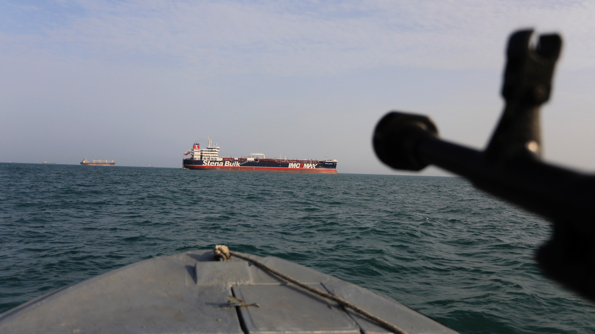 A speedboat belonging to Iran's Revolutionary Guard Corps trains a weapon toward the British-flagged oil tanker Stena Impero, which was seized in the Strait of Hormuz on July 19. (AP/Tasnim News Agency)