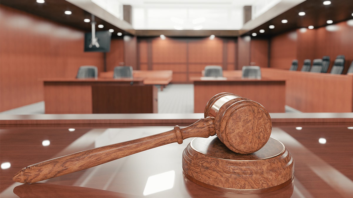 gavel shown close up, courtroom in background