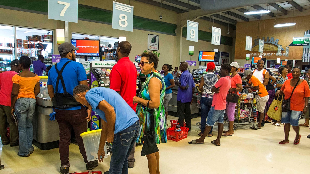 Residents stand in line at a grocery store as they prepare for the arrival of Tropical Storm Dorian, in Bridgetown, Barbados, Monday, Aug. 26, 2019.