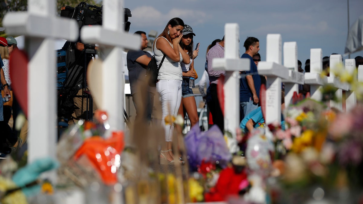 People visit a makeshift memorial, Monday, Aug. 5, 2019, at the site of a mass shooting at a shopping complex, in El Paso, Texas.