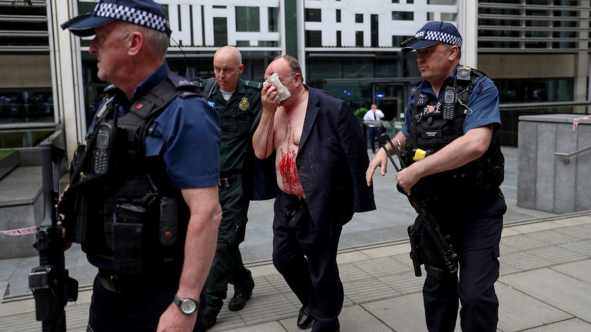 An injured man is helped by a medic and police officers outside the Home Office in London, Britain August 15, 2019.