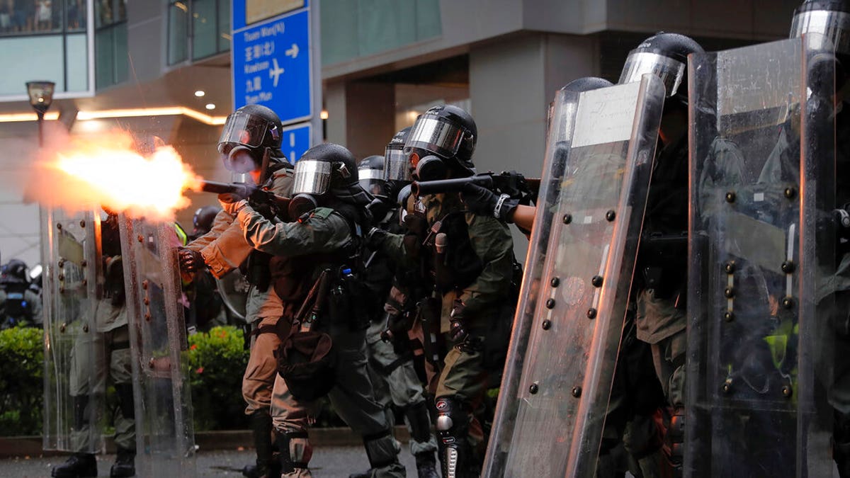 Riot police fires tear gas at protesters during a protest in Hong Kong, Sunday, Aug. 25, 2019. Police were skirmishing with protesters in Hong Kong for a second straight day on Sunday following a pro-democracy march in an outlying district. (AP Photo/Kin Cheung)
