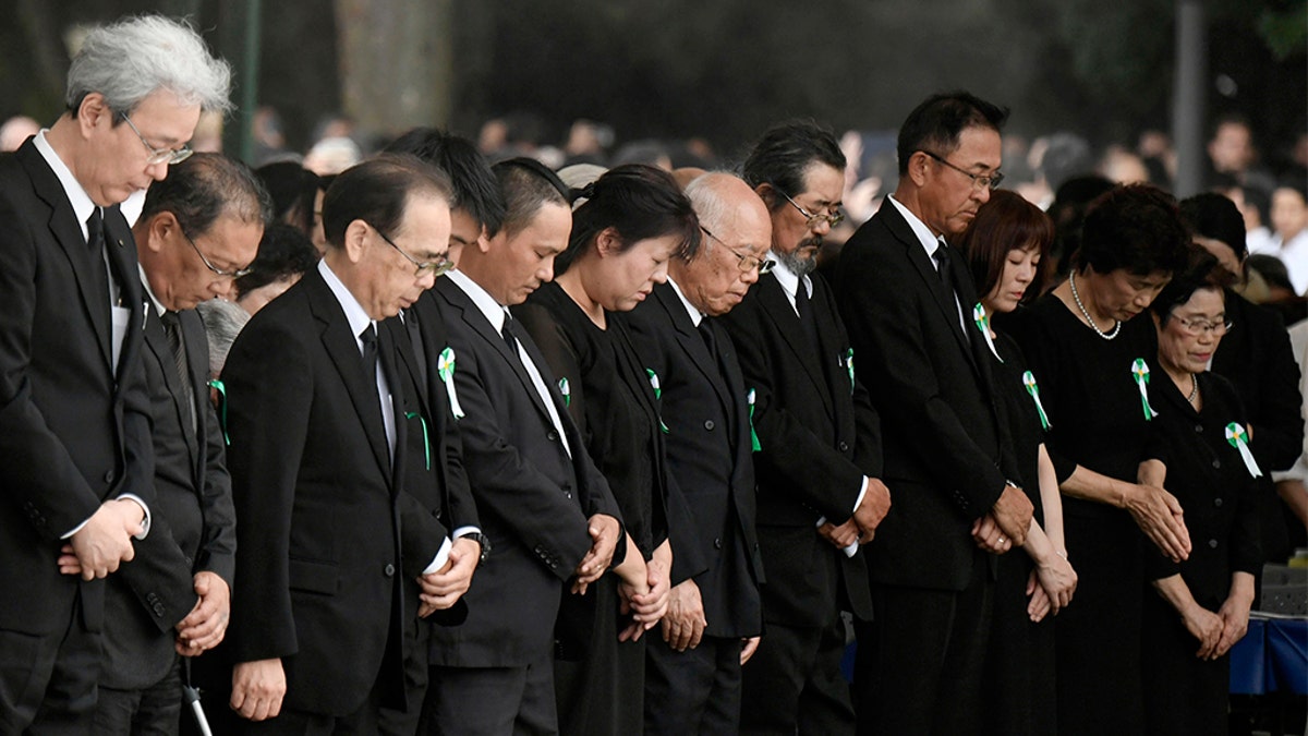 People offer silent prayer during a ceremony to mark the 74th anniversary of the atomic bombing at the Hiroshima Peace Memorial Park in Hiroshima, western Japan Tuesday, Aug. 6, 2019. (Kyodo News via AP)