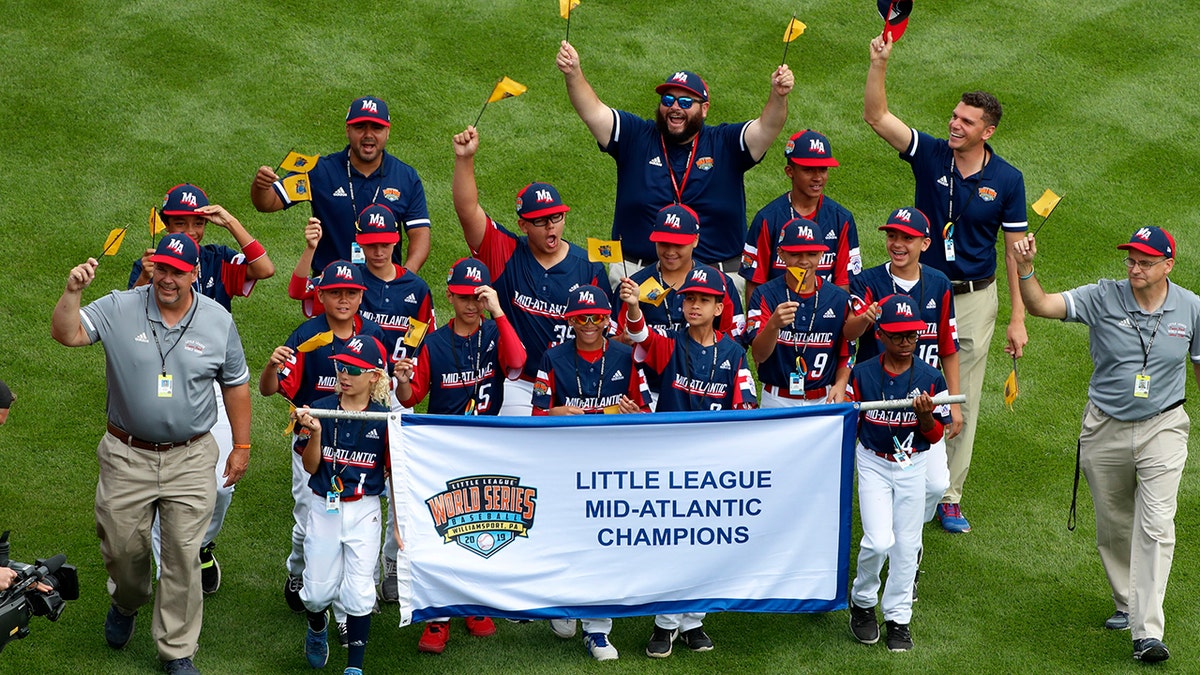 FILE - In this Aug. 15, 2019, file photo, the Mid-Atlantic Region Champion Little League team from Elizabeth, N.J. participates in the opening ceremony of the 2019 Little League World Series baseball tournament in South Williamsport, Pa. With each game it plays at the Little League World Series, the Elmora Youth League team from Elizabeth, New Jersey, shares the memory of Thomas Hanratty, a state trooper who was killed during a traffic stop in 1992. (AP Photo/Gene J. Puskar, File)