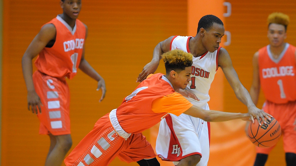 Photo shows Coolidge High's Lamar Lee-Kane, left, fouling Woodson High's Dion Crumlin during a tournament game in Washington D.C. in 2015. (Photo by John McDonnell/The Washington Post via Getty Images)