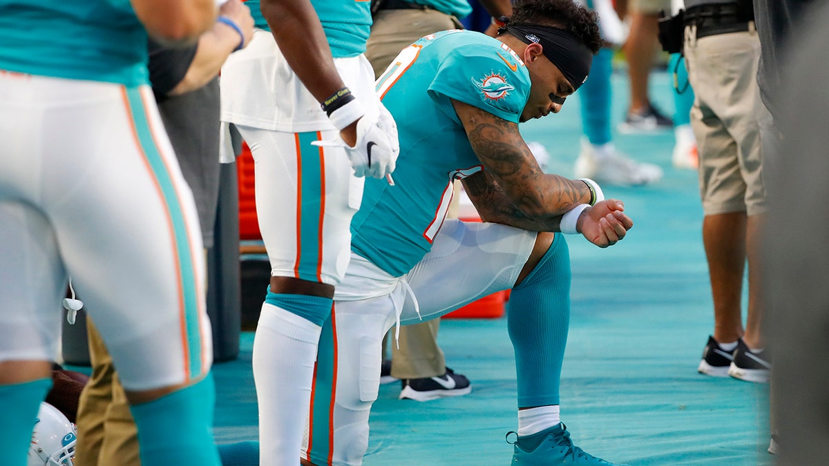 Miami Dolphins wide receiver Kenny Stills kneels during the national anthem before the team's preseason NFL football game against the Atlanta Falcons, Thursday, Aug. 8, 2019, in Miami Gardens, Fla. (AP Photo/Wilfredo Lee)