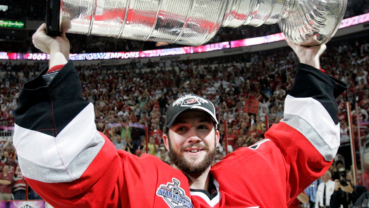 FILE - In this June 19, 2006, file photo, Carolina Hurricanes goaltender Cam Ward hoists the Stanley Cup after the Hurricanes defeated the Edmonton Oilers 3-1 in Game 7 of the Stanley Cup hockey finals in Raleigh, N.C. Goalie Cam Ward has signed a one-day contract with the Carolina Hurricanes and is retiring as a member of the team he helped lead to a Stanley Cup. General manager Don Waddell announced the signing and retirement Wednesday, Aug. 28, 2019, calling Ward “a cornerstone for this organization for more than a decade.”(AP Photo/Ann Heisenfelt, File)