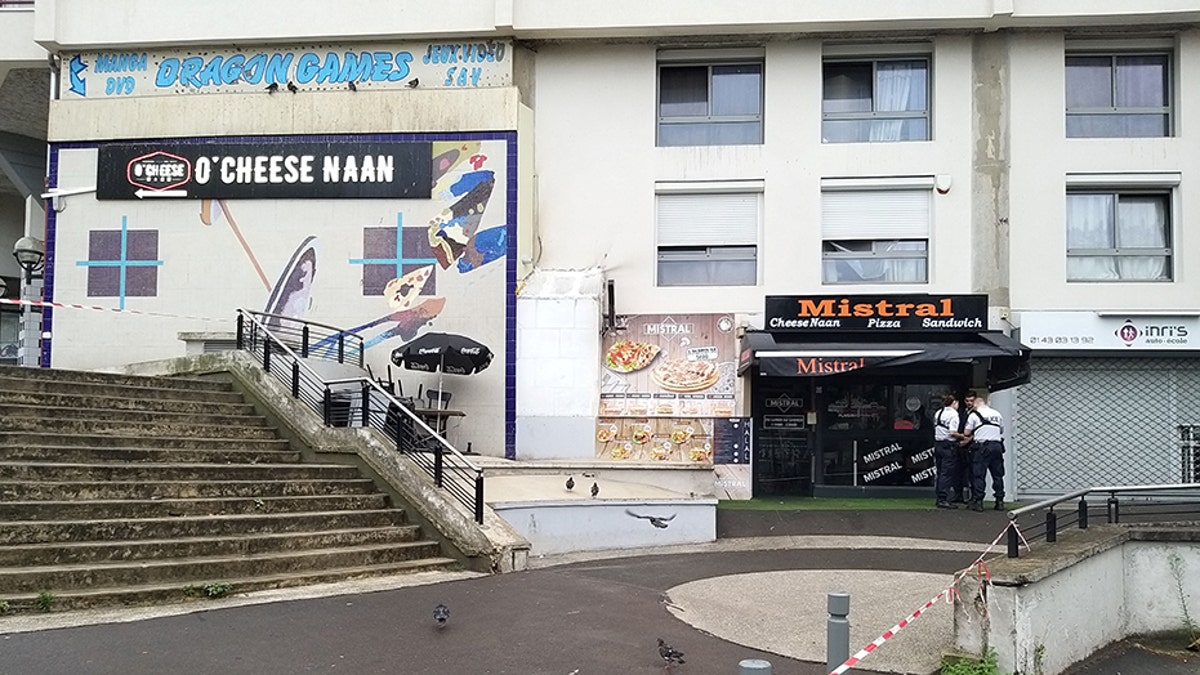 Policemen stand in front of the eatery on Saturday where a waiter was shot dead by a customer allegedly angry at having to wait for a sandwich, in the eastern Paris suburb of Noisy-le-Grand.