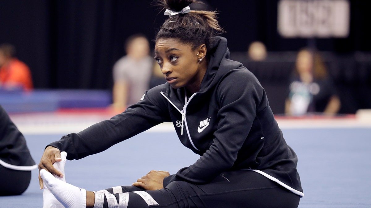 Simone Biles stretches during practice for the U.S. Gymnastics Championships Wednesday, Aug. 7, 2019, in Kansas City, Mo. (AP Photo/Charlie Riedel)