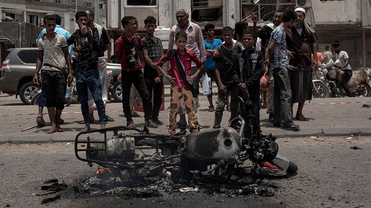 Civilians gather at the site of a deadly attack in Aden, Yemen, Thursday, Aug. 1, 2019. Yemen's rebels have fired a ballistic missile at a military parade in the southern port city of Aden as coordinated suicide bombings targeted a police station in another part of the city. The attacks killed at least 51 people and wounded dozens. (AP Photo/Nariman El-Mofty)