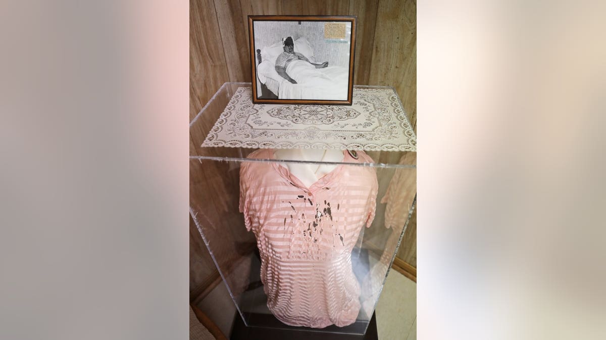 EDS NOTE: GRAPHIC CONTENT - In this Aug. 9, 2019, photo a photograph of Rhoda Wise and the dress she wore in the photo when she suffered the phenomenon of stigmata, bloody wounds on her head, hands and feet like those Jesus suffered on the Cross, is displayed in Canton, Ohio. Late in the summer of 1939, crowds of strangers started showing up at Rhoda Wise's house next to a city dump in Ohio after she let it be known that miracles were occurring in her bedroom. Seven decades later, people still make pilgrimages to the wood frame bungalow at the edge of Canton seeking their own miracles.