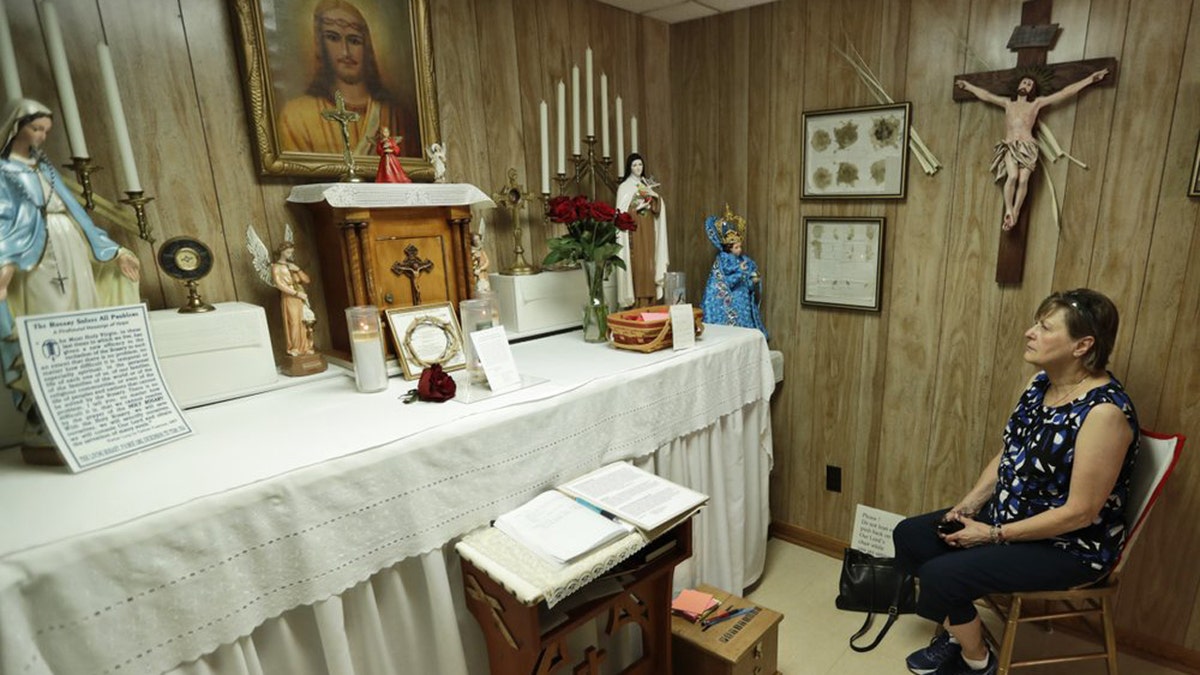 In this Aug. 9, 2019, photo Marge Ruminski, from Parma, Ohio, sits in the chair where Rhoda Wise was visited by Jesus Christ in front of the altar in Canton, Ohio.