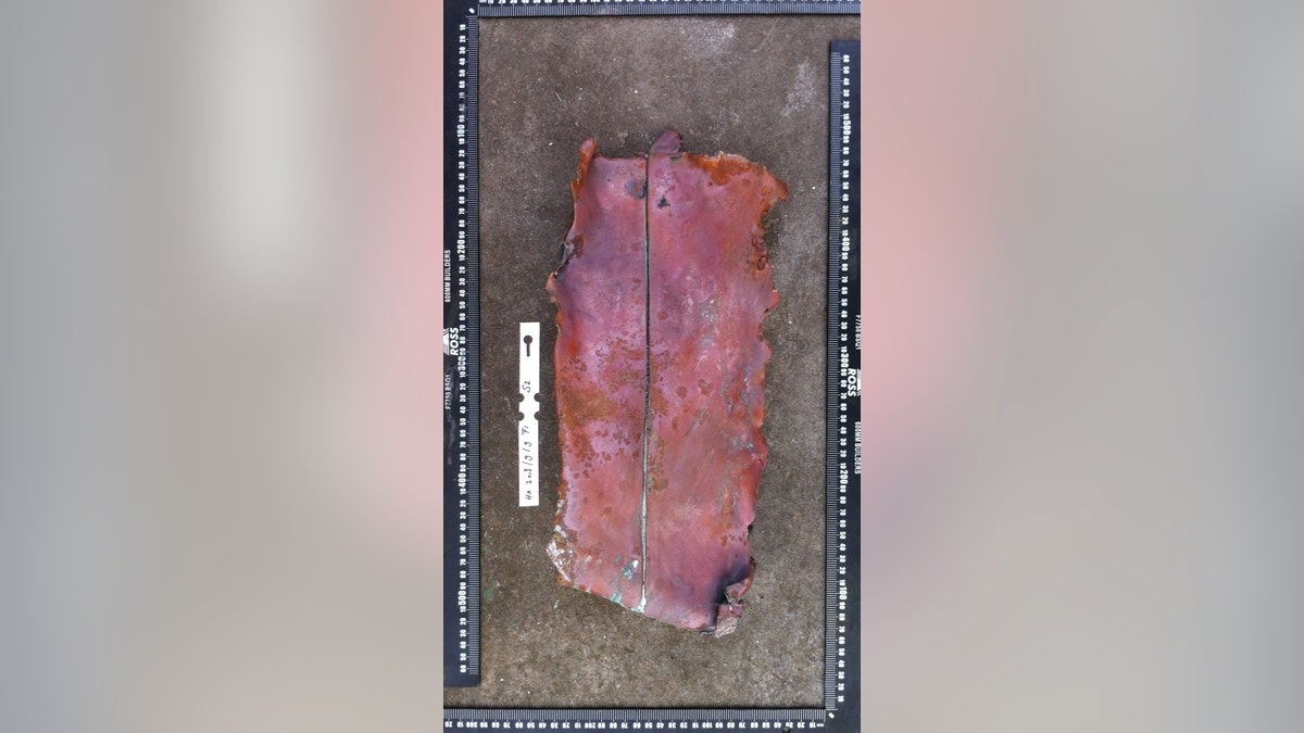 Fragment of a metal composite plate excavated on Sept. 9, 2018. It consists of a layer of copper, backed by a layer of lead. Historical information indicates that the stern post and rudder of Dutch East India Company ships like 'Haarlem' used plates such as this. (©AIMURE/Bruno Werz) 
