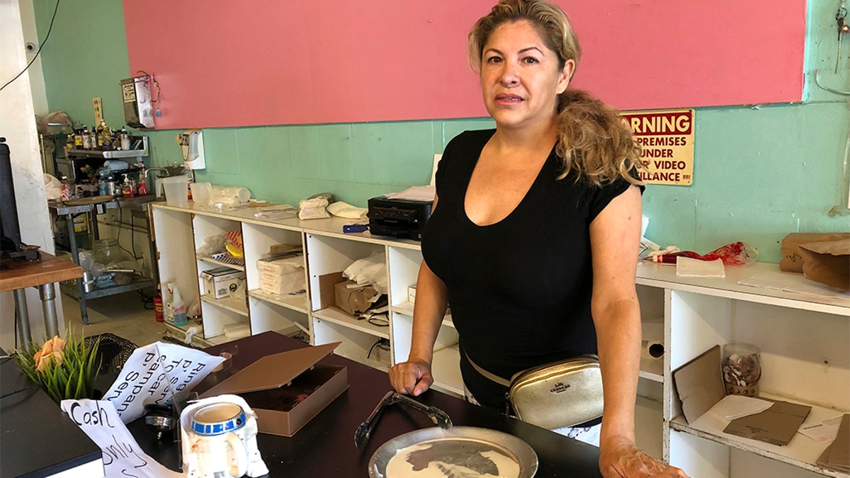 Dona Beltran, owner of M Bakery is seen behind her bakery counter in Garden Grove, Calif., Thursday, Aug. 8, 2019. She said the suspect came in late Wednesday afternoon and took the entire cash register. She said she ran to a nearby dental office to safety when she saw she was being robbed. 