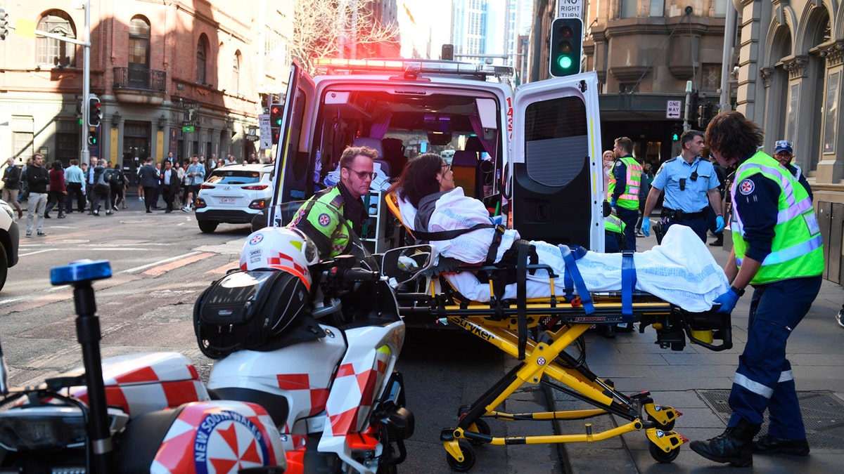 A women is taken by ambulance from Hotel CBD at the corner of King and York Street in Sydney, Australia Tuesday, Aug. 13, 2019.