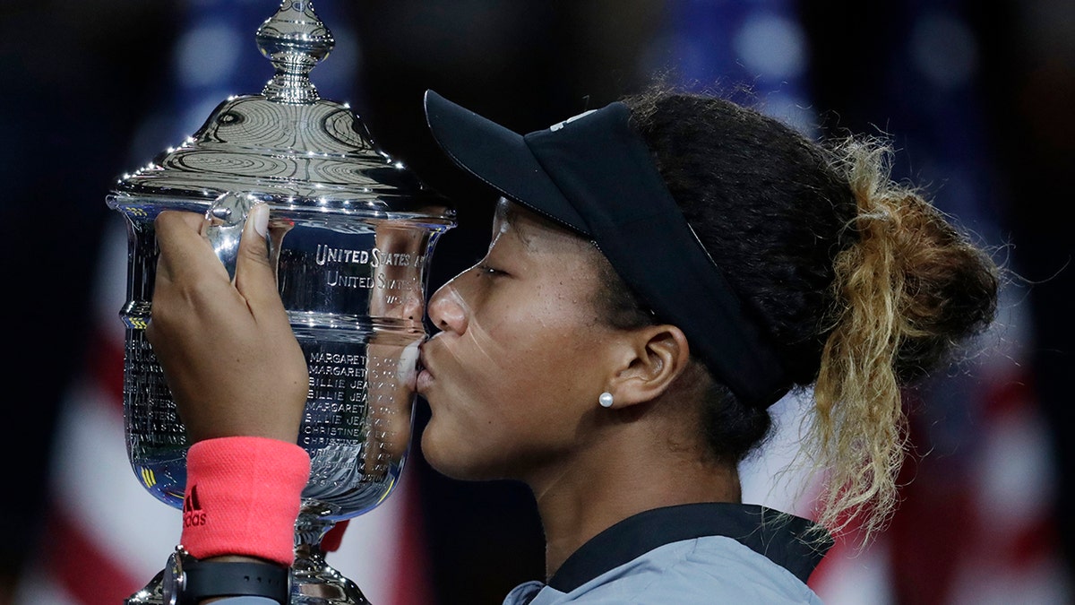 Naomi Osaka, of Japan, kisses the trophy after defeating Serena Williams, of the U.S., in the women's final of the U.S. Open tennis tournament in New York on Sept. 8, 2018. (AP Photo/Julio Cortez, File)