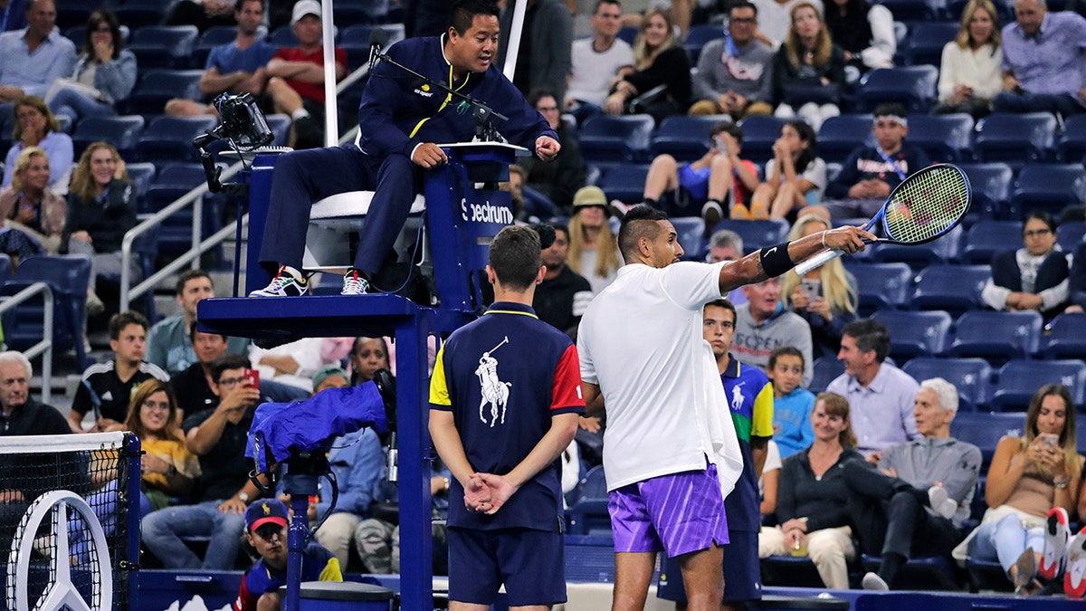 Nick Kyrgios, of Australia, points out distractions in the crowd during his match against Steve Johnson, of the United States, during the first round of the U.S. Open tennis tournament in New York, early Wednesday, Aug. 28, 2019. (AP Photo/Charles Krupa)