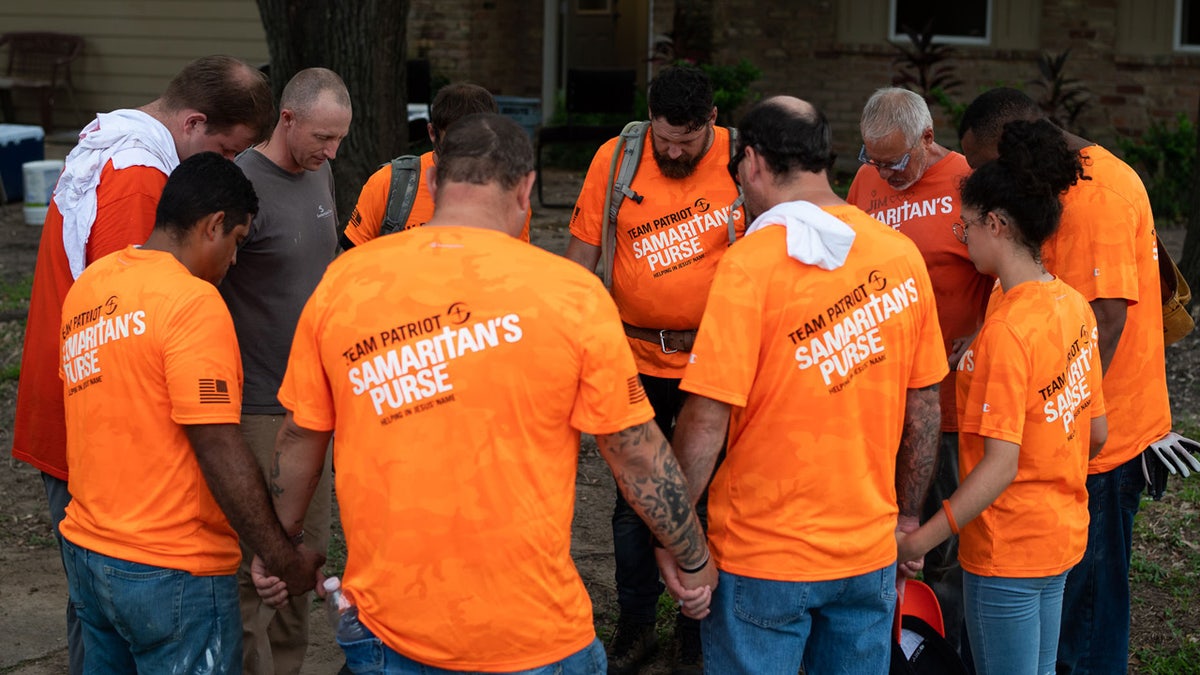 Team Patriot members pray after a day spent installing bathrooms, repairing windows and laying trim at a home devastated by Hurricane Harvey.