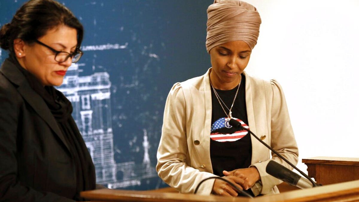 Rep. Ilhan Omar, D-Minn., right, and Rep. Rashida Tlaib, D-Mich., take a quiet moment as they talked about Israel's refusal to allow them to visit the country during a news conference Monday, Aug. 19, 2019 at the State Capitol in St. Paul, Minn. (AP Photo/Jim Mone)