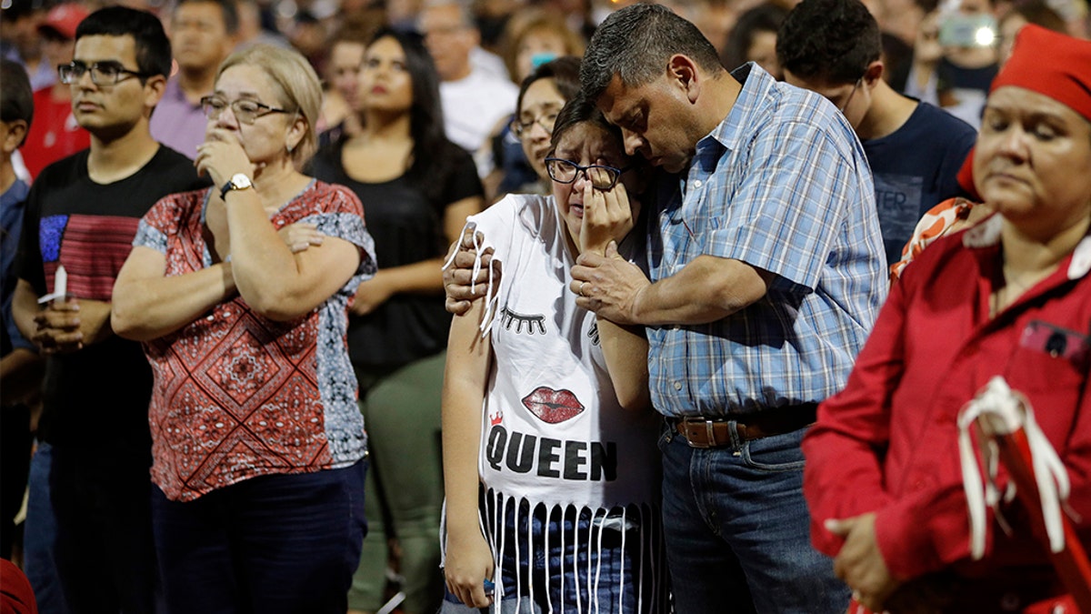 People comfort each other during a vigil for victims of Saturday's mass shooting at a shopping complex Sunday, Aug. 4, 2019, in El Paso, Texas. 