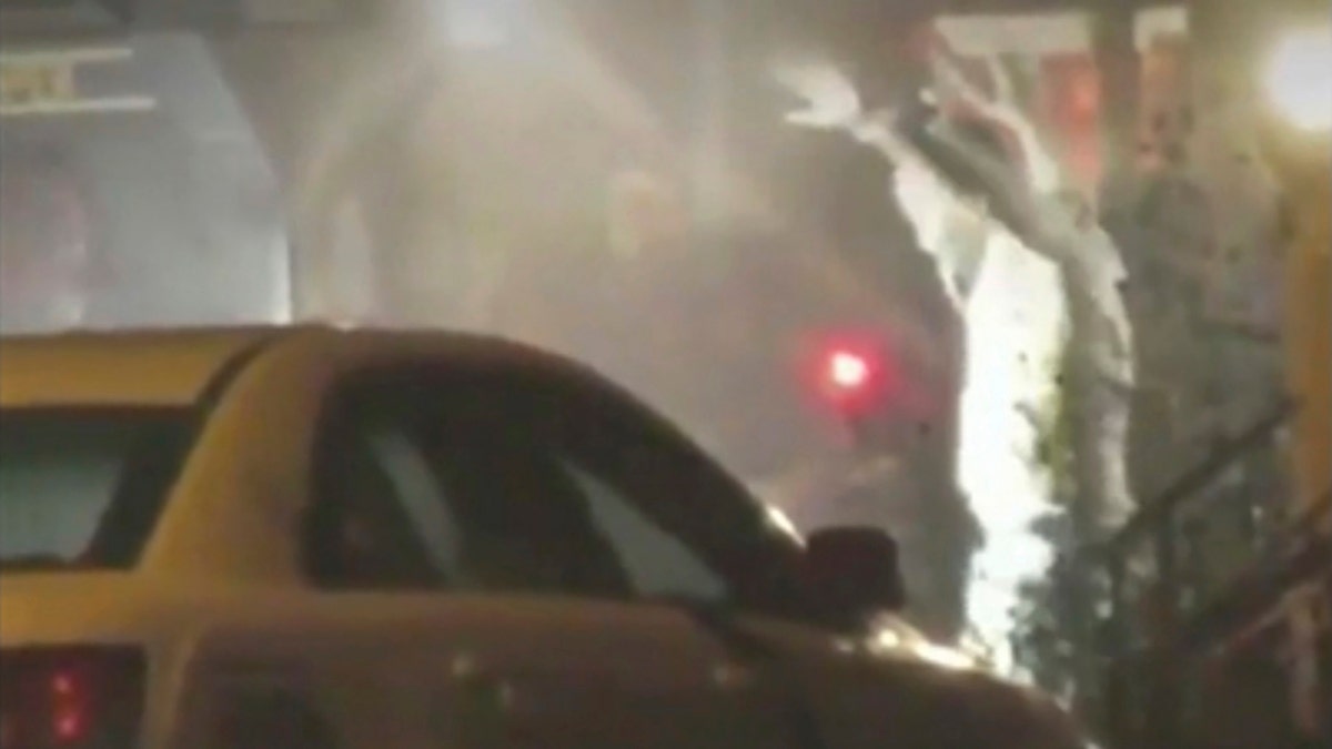 In this image from video taken by Bill Trenwith on Wednesday, Aug. 14, 2019, a Maurice Hill exits a building with hands up in Philadelphia, Pennsylvania.