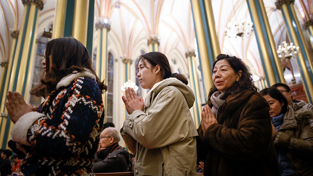 Chinese worshippers attend a Mass during Christmas Eve at a Catholic church in Beijing on December 24, 2018. (Photo by WANG ZHAO / AFP) (Photo credit should read WANG ZHAO/AFP/Getty Images)