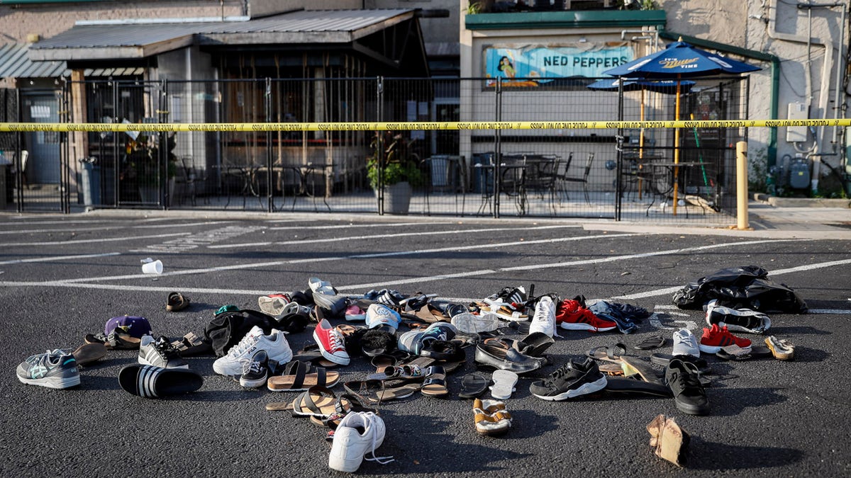 Shoes are piled outside the scene of a mass shooting including Ned Peppers bar, Sunday, Aug. 4, 2019, in Dayton, Ohio.