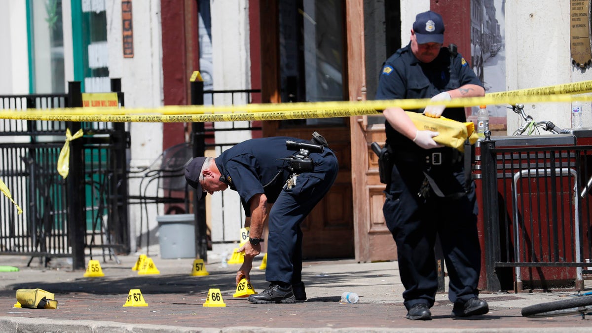 Authorities retrieve evidence markers at the scene of a mass shooting, Sunday, Aug. 4, 2019, in Dayton, Ohio.