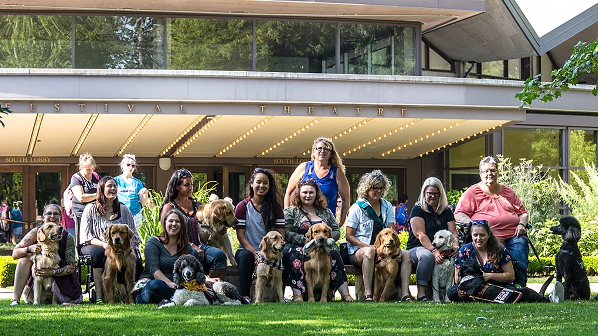 All the dogs and their training handlers outside the theater.
