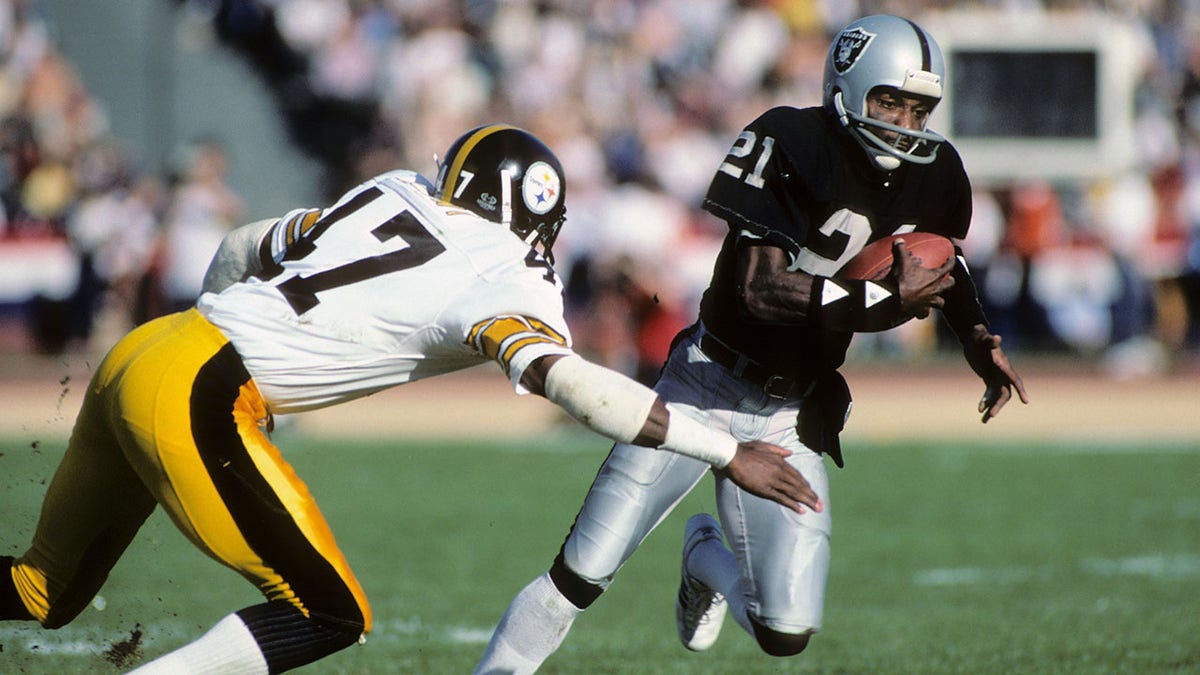 Cliff Branch, right, of the then-Los Angeles Raiders, runs the ball against Mel Blount of the Pittsburgh Steelers during an AFC playoff game in Los Angeles, Jan. 1, 1984. (Getty Images)