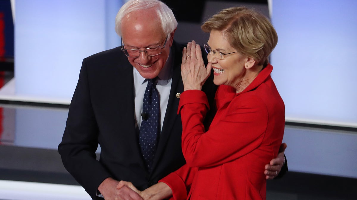 Democratic presidential candidate Sen. Bernie Sanders (I-VT) and Sen. Elizabeth Warren (D-MA) greet each other at the start of the Democratic Presidential Debate at the Fox Theatre in Detroit on July 30, 2019.