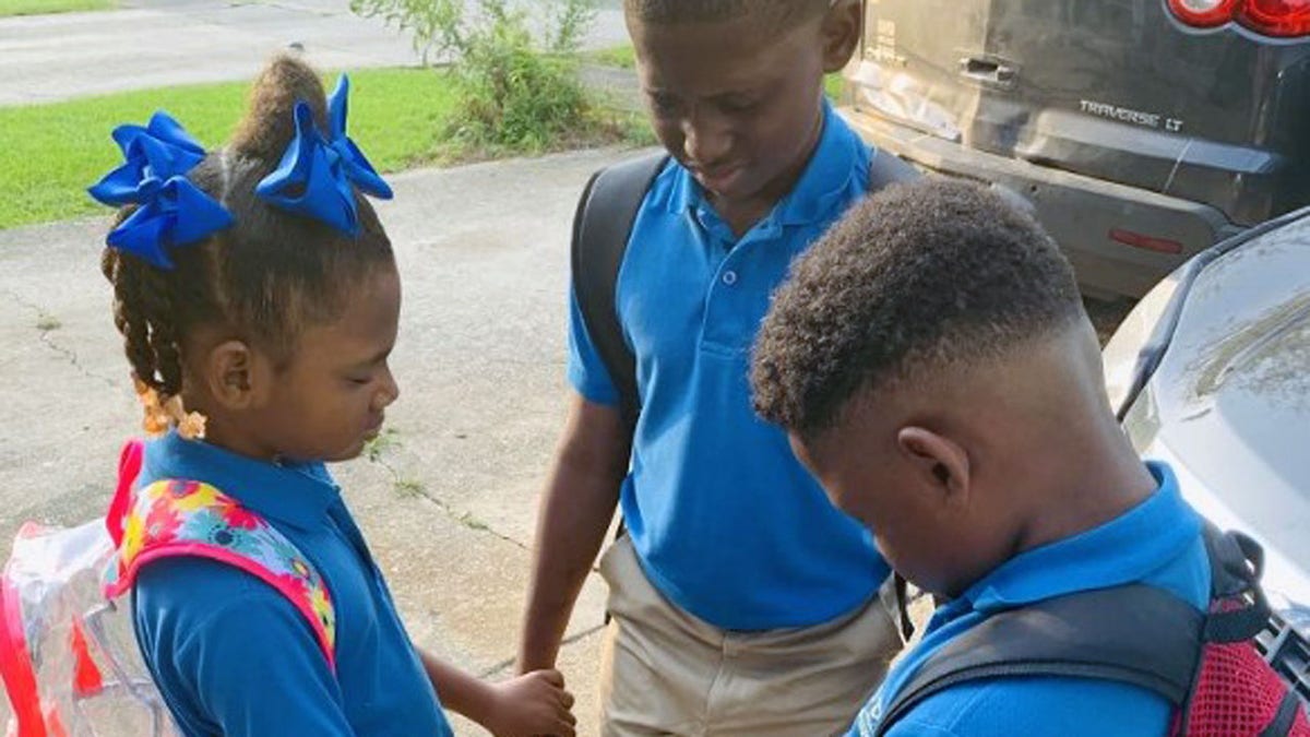 Jamisha Harris shared a photo of her children Eugene Jacobs, 10, Jorden Jacobs, 8, and Emily Jacobs, 7, praying before their first day of school.