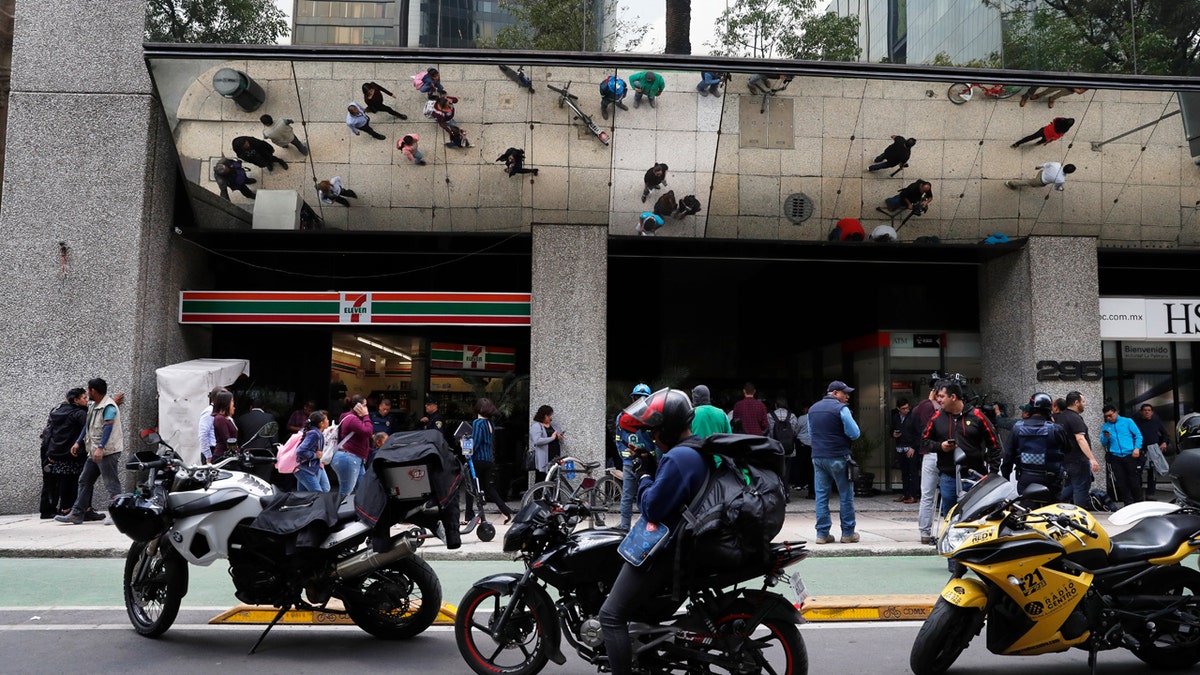 Journalists gather outside the federal mint's headquarters in Mexico City, Tuesday, Aug. 6, 2019. Mexican authorities say gunmen raided the federal mint's headquarters and took items from a vault.