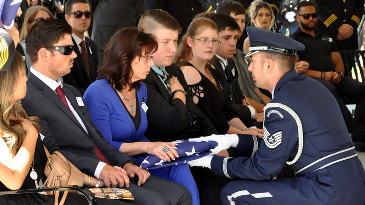 An American flag is presented to McKeithen's wife, Pamela, during a service at the Biloxi National Cemetery. McKeithen was an Air Force veteran.