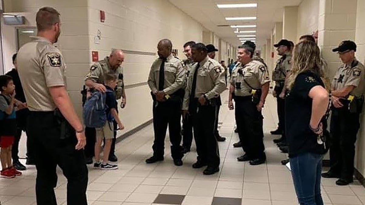 Caden Dixon, 9, is escorted to his class by the Hall County Sheriff's Office.