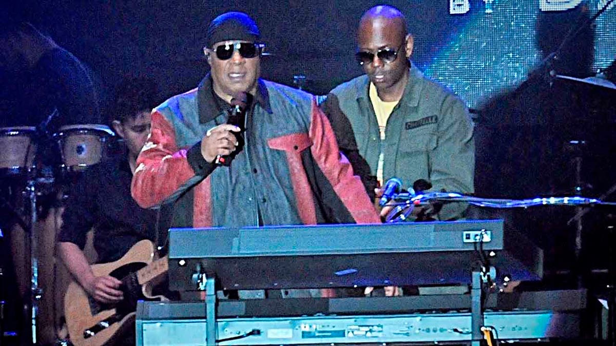 Musician Stevie Wonder, front left, and comedian Dave Chappelle appear on stage during the 