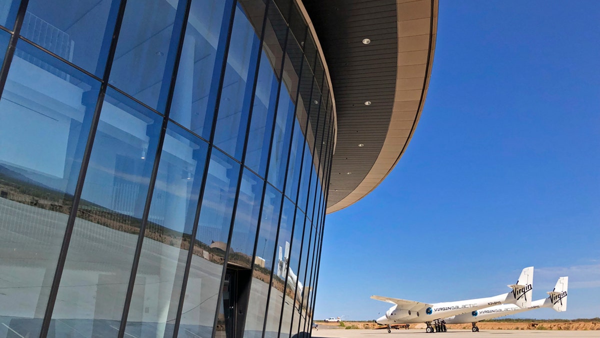 Virgin Galactic's carrier plane makes its way across the apron in front of Spaceport America following a test flight over its new permanent home near Upham, New Mexico, on Thursday, Aug. 15, 2019. Virgin Galactic on Thursday unveiled two levels of its new digs at the spaceport, which includes a social hub where crew, pilots and customers and their families can mingle. (AP Photo/Susan Montoya Bryan)
