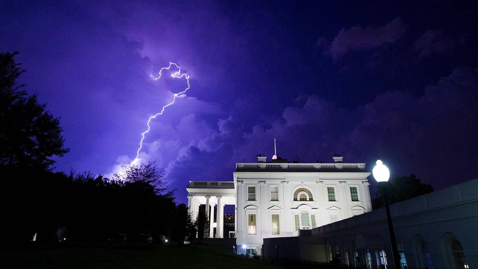 A bolt of lightning illuminates clouds over the White House during a thunderstorm in Washington, Aug. 6, 2019. 