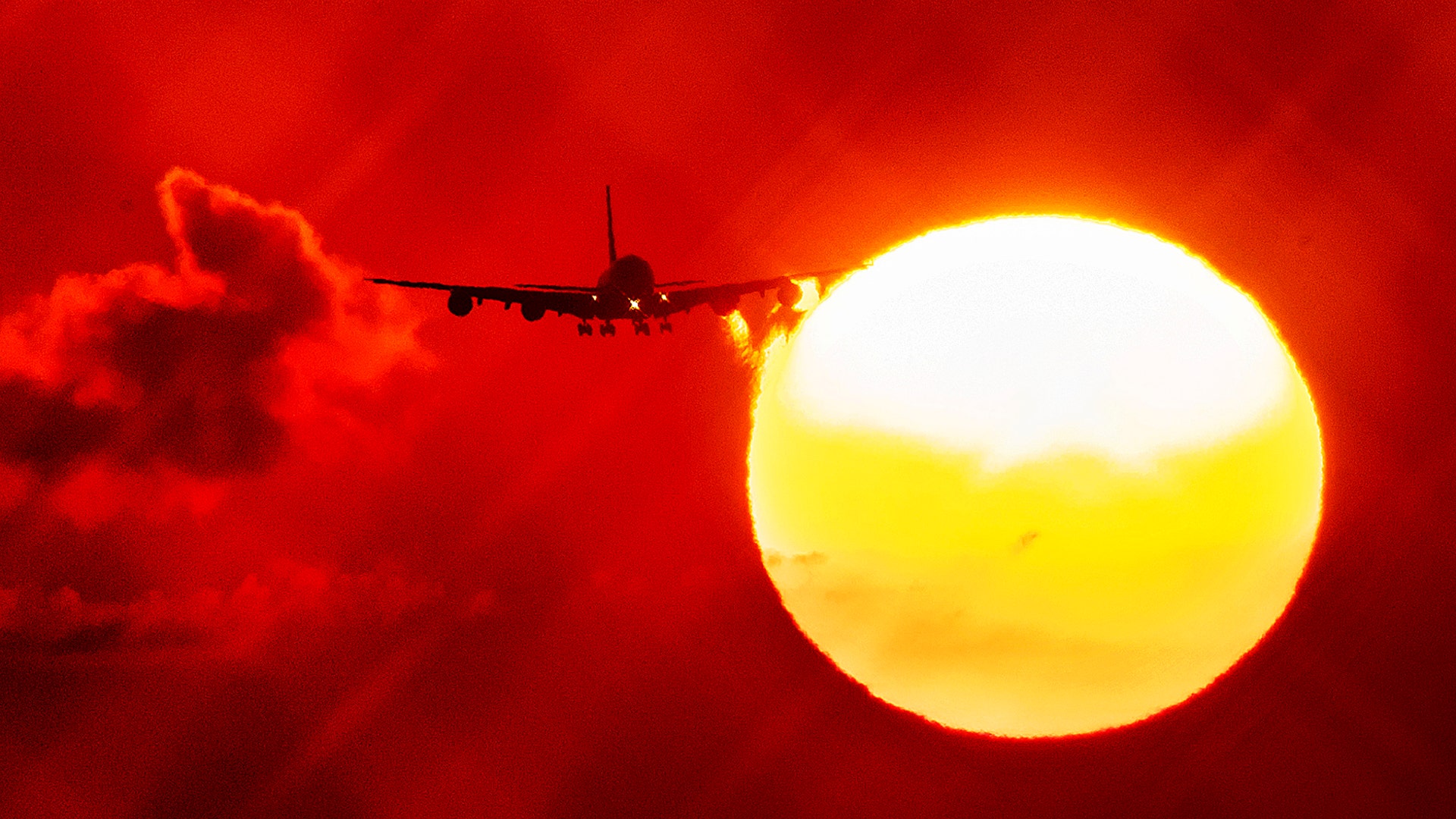 An airplane passes the rising sun as it approaches the airport in Frankfurt, Germany, Aug. 21, 2019. 