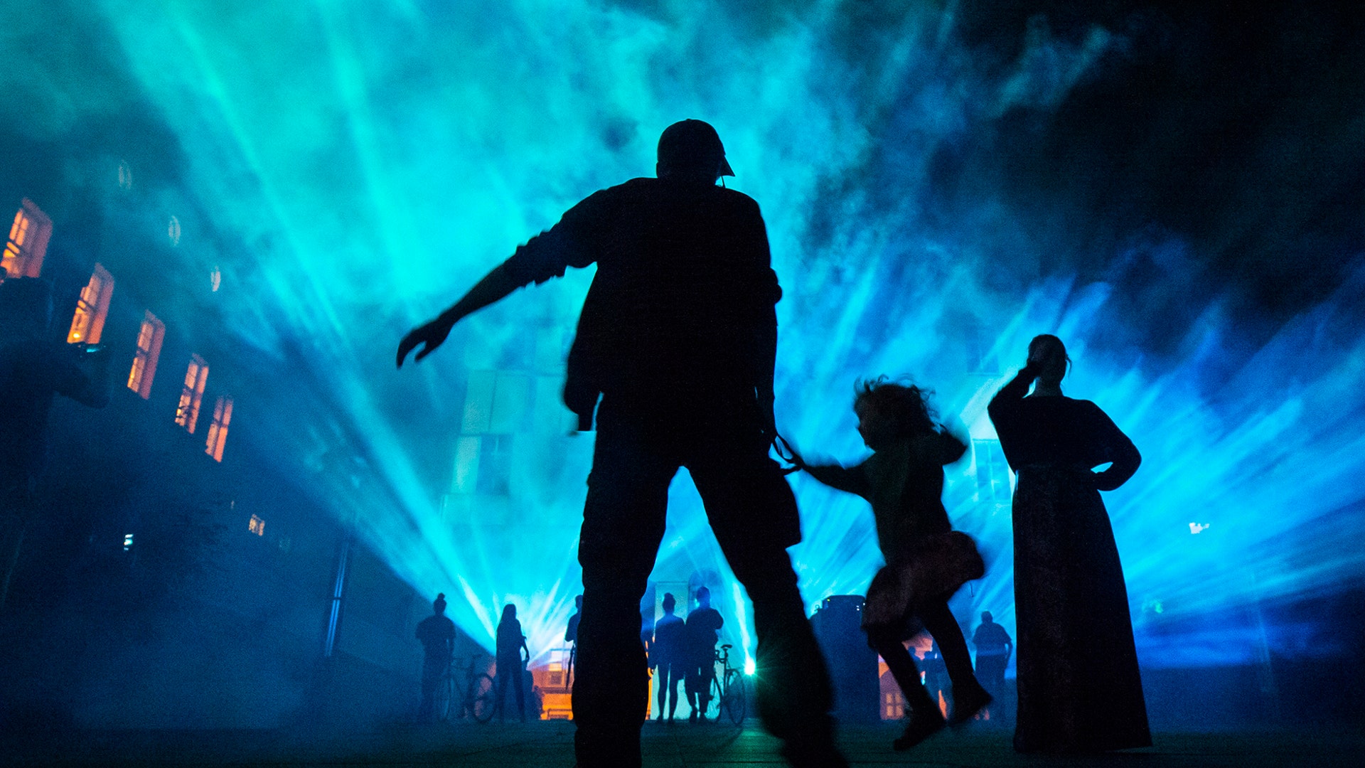 Visitors stand in front of a wall projection during the Genius Loci Festival in Weimar, Germany, Aug. 11, 2019.